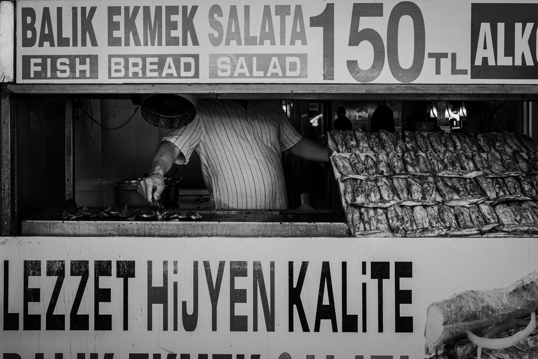 Letrero de un puesto de pescado con precios y mención a la higiene alimentaria.