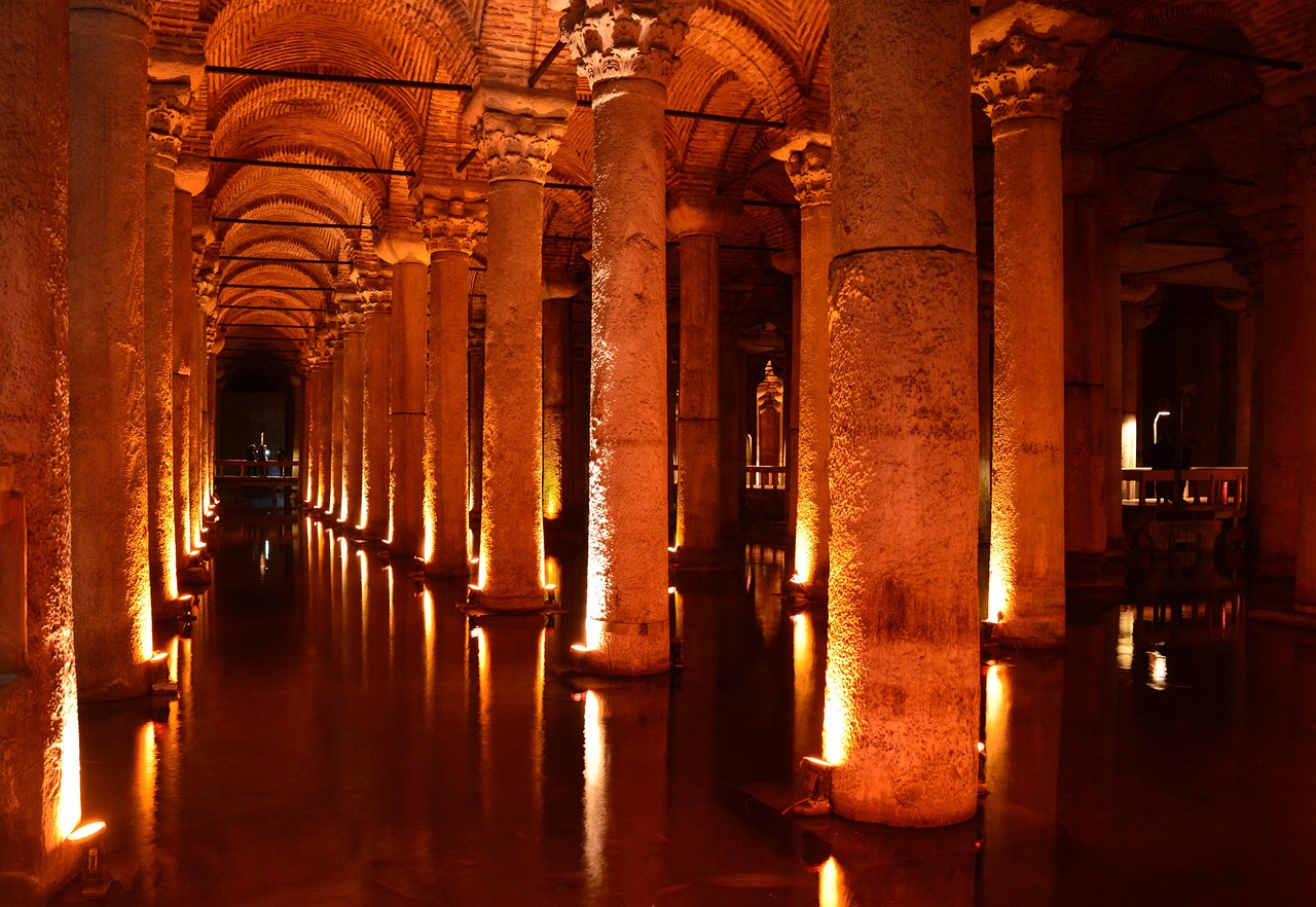 Columnas de mármol iluminadas reflejándose en el agua de la Cisterna Basílica de Estambul.