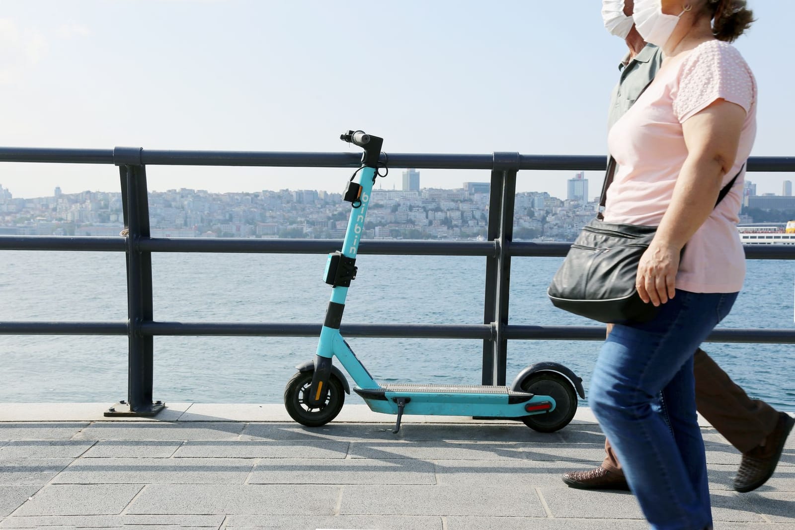 Patinete BinBin estacionado junto al mar en el paseo del Bósforo en Estambul.