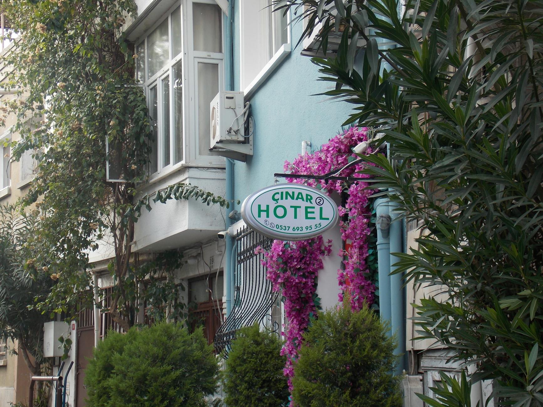 Fachada adornada con flores del Hotel Çinar en una calle de Estambul.