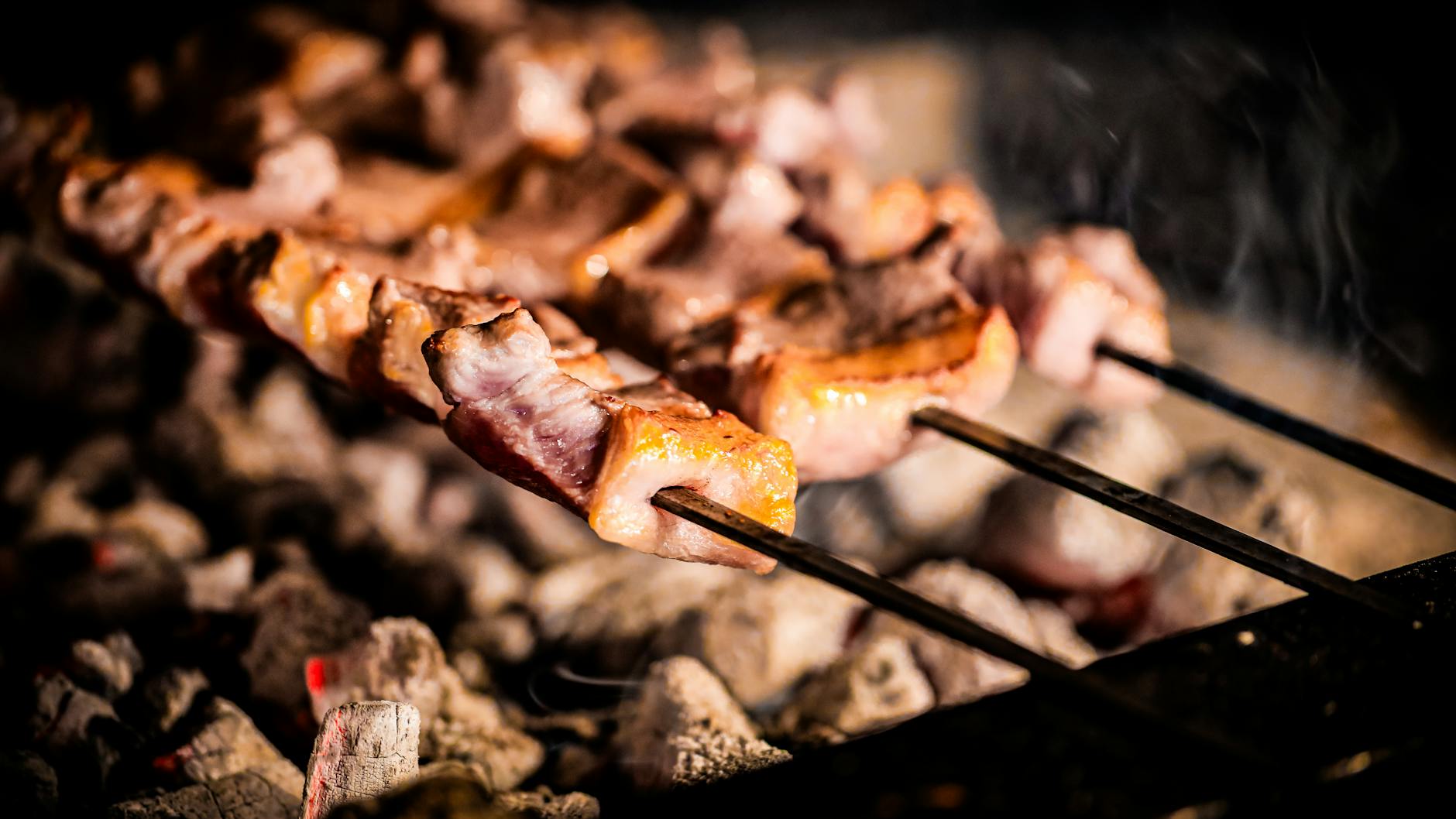 Brochetas de auténtico Cağ Kebabı cocinándose sobre brasas de carbón en Estambul.