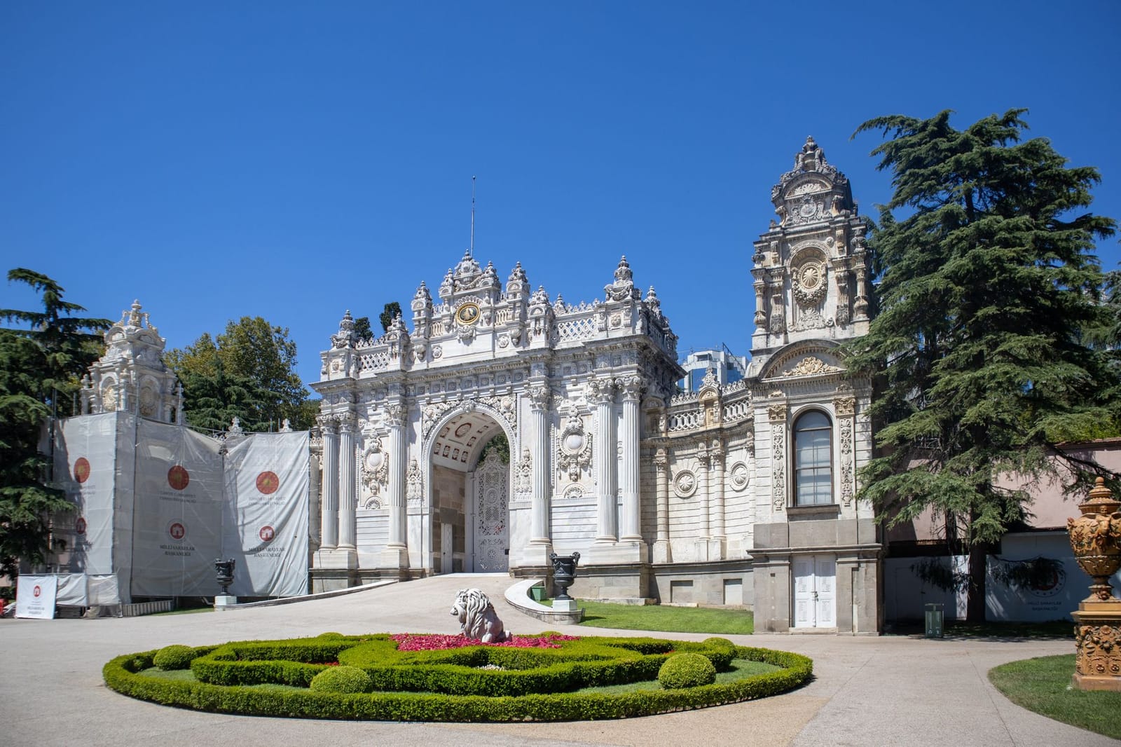 Puerta monumental del palacio de Dolmabahçe con detalles tallados en mármol blanco.
