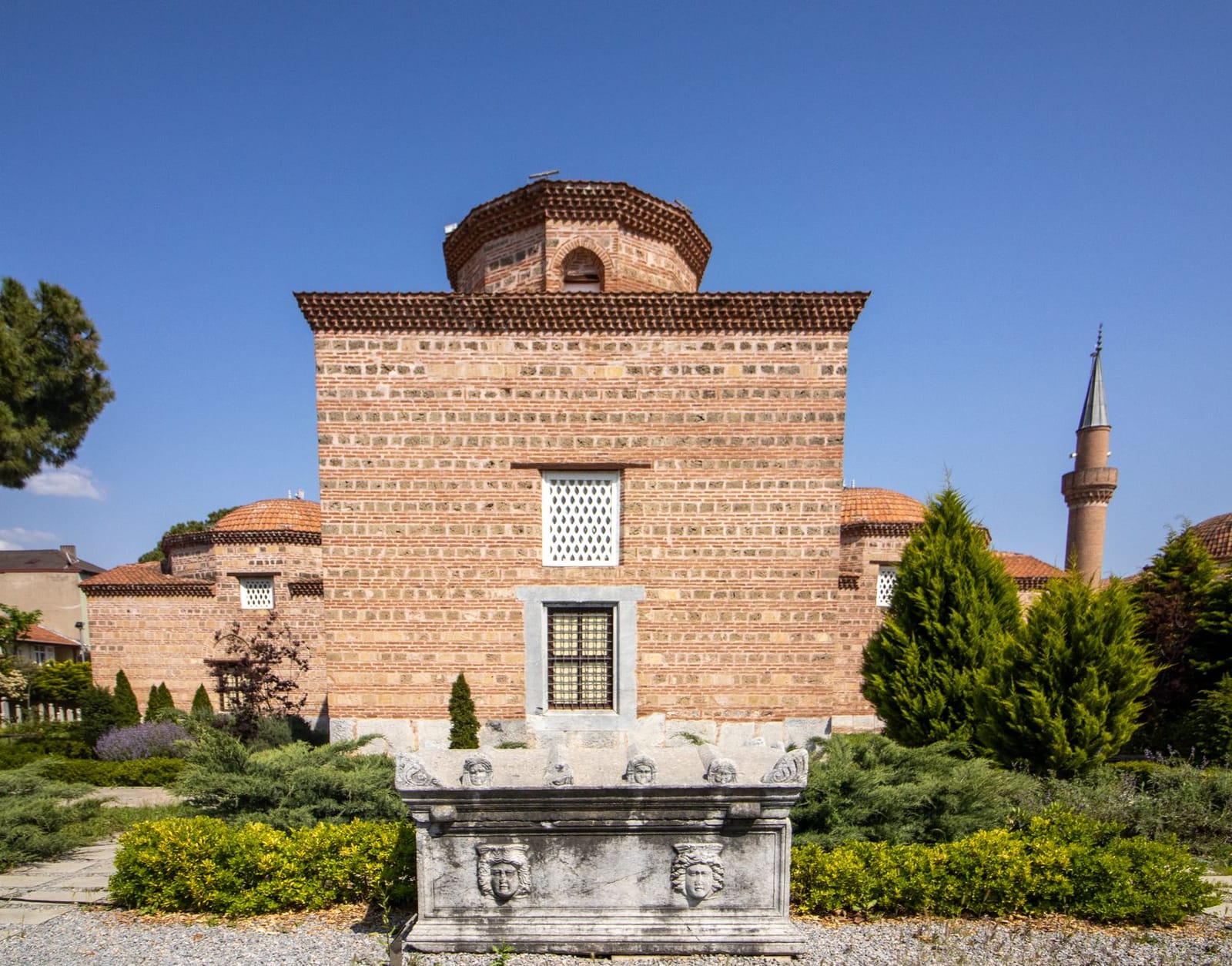 Antiguo edificio otomano de ladrillo con un sarcófago histórico en Bursa.