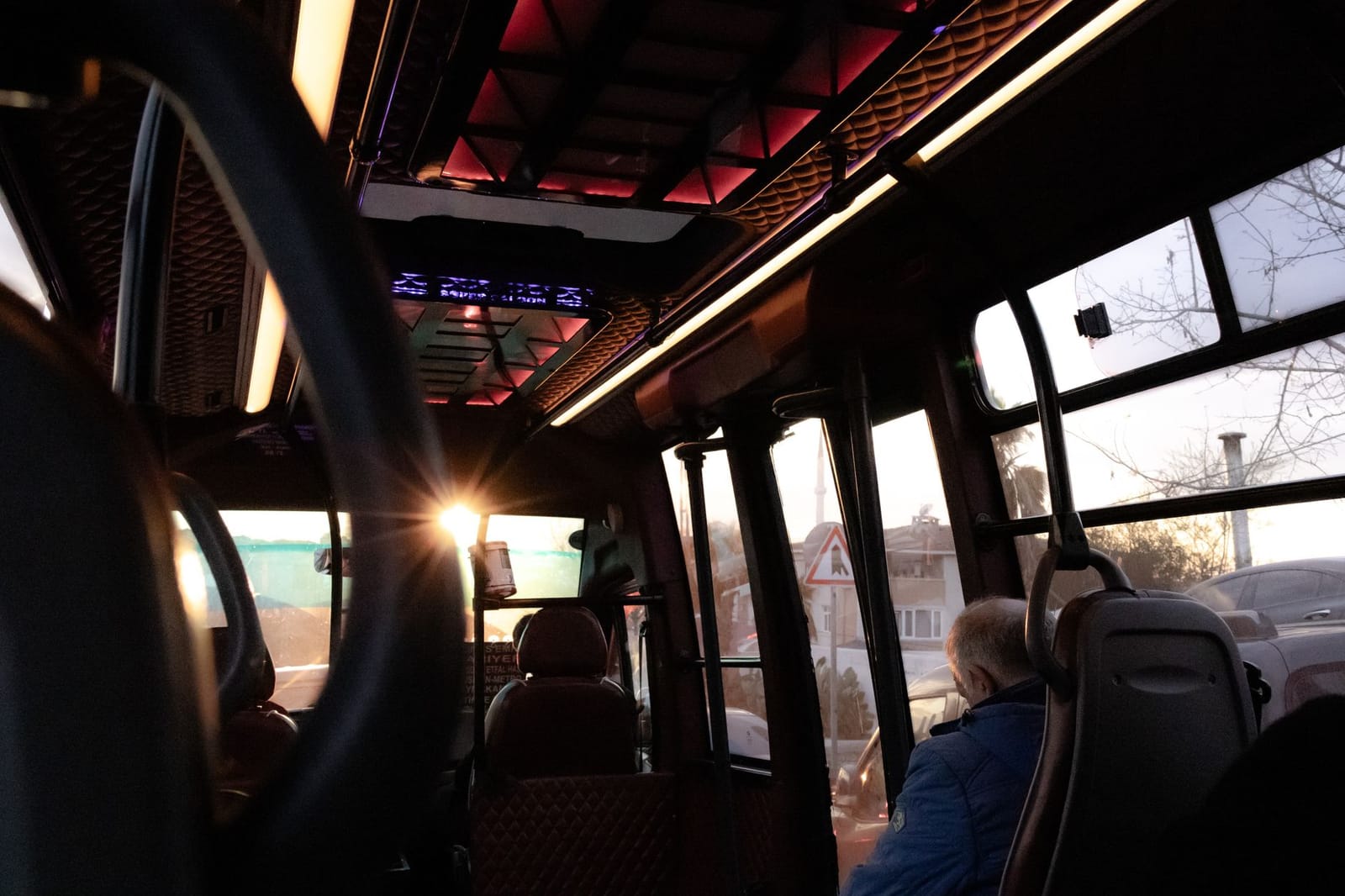 Interior de un dolmuş turco iluminado al atardecer durante el recorrido.