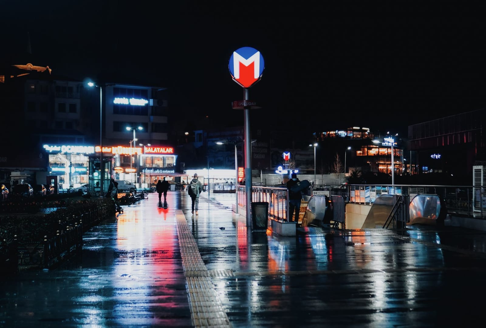 Entrada iluminada a la estación de metro en Estambul durante una noche lluviosa.