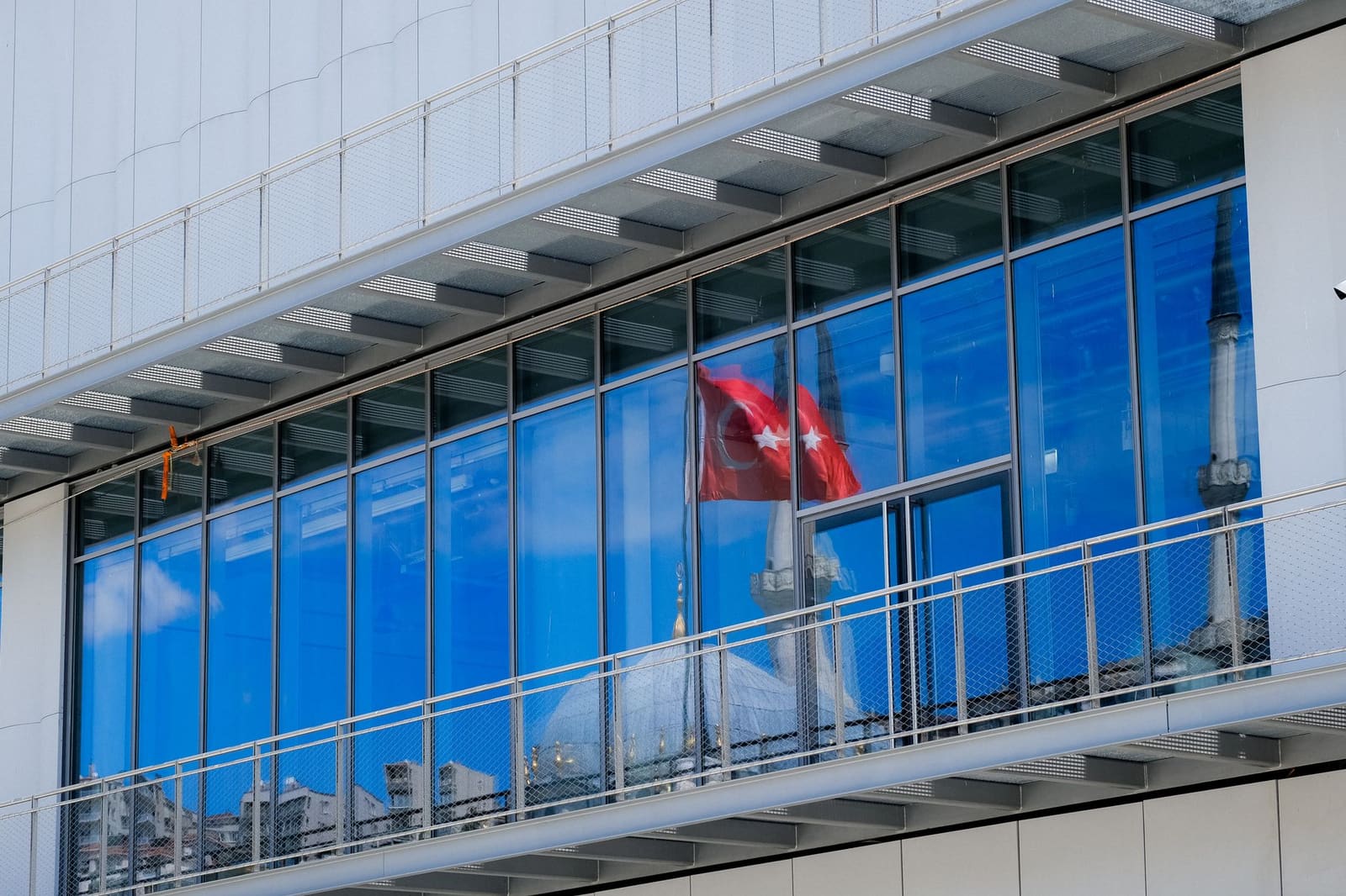 Fachada acristalada del museo Istanbul Modern reflejando una mezquita cercana.