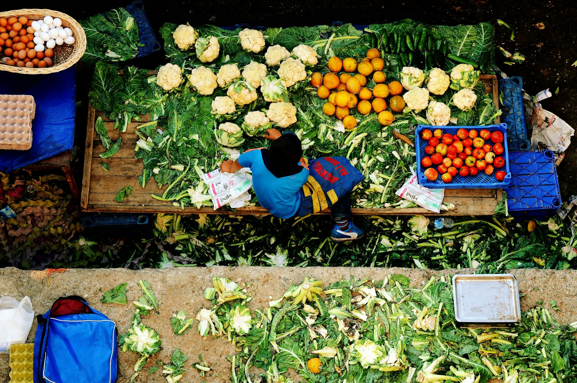 Un niño organiza coliflores y naranjas en un mercado callejero de Estambul.