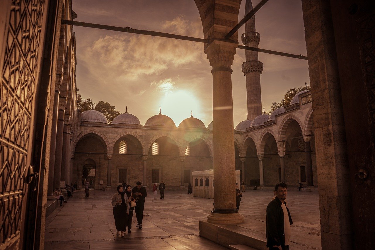 Atardecer dorado iluminando el patio interior de una mezquita histórica en Estambul.