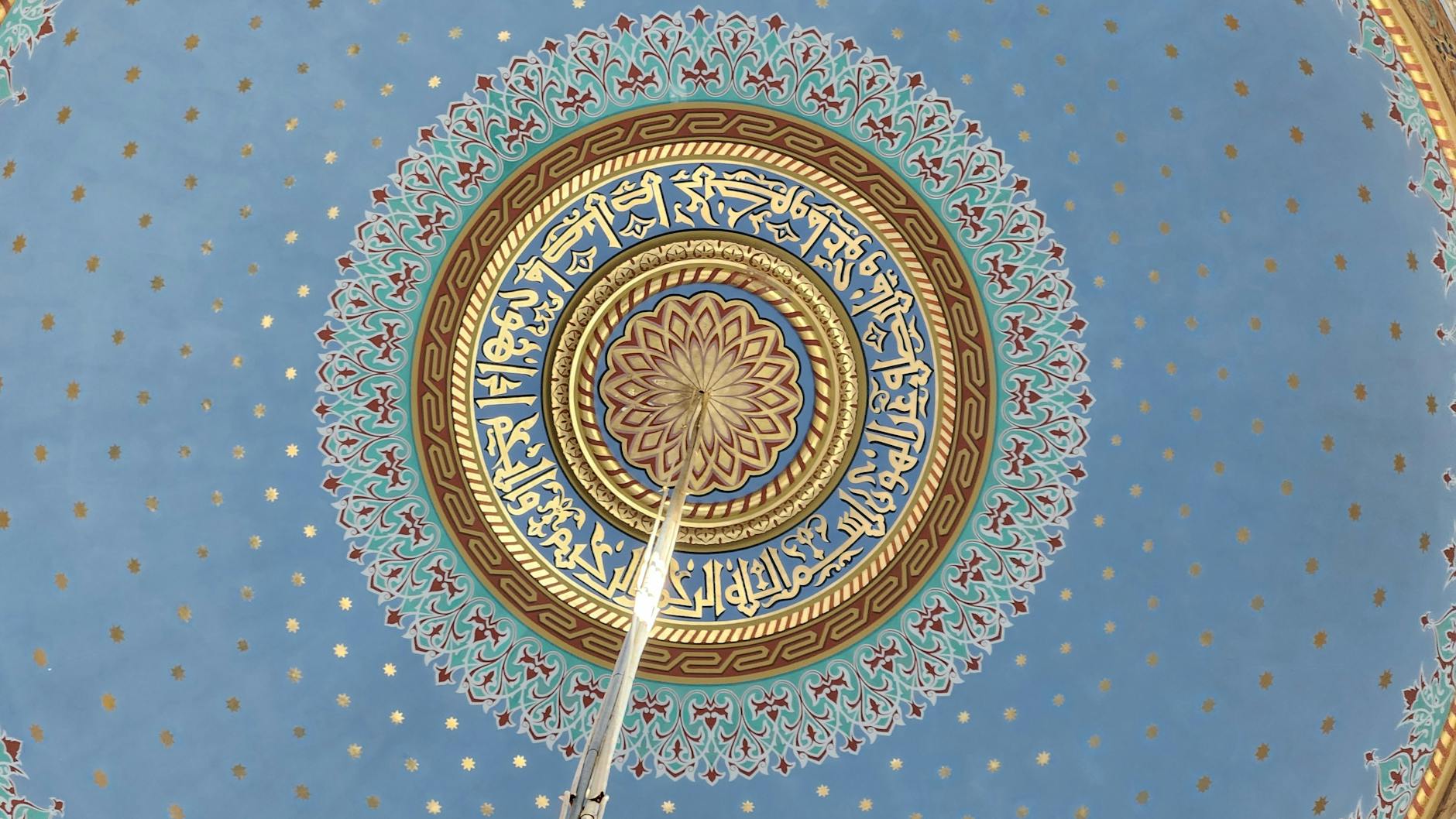 Decoración geométrica y caligrafía religiosa en el interior de la cúpula de una mezquita.