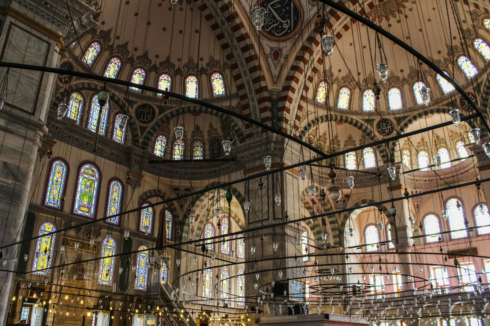 Lámparas colgantes y vitrales coloridos en el interior de la mezquita.