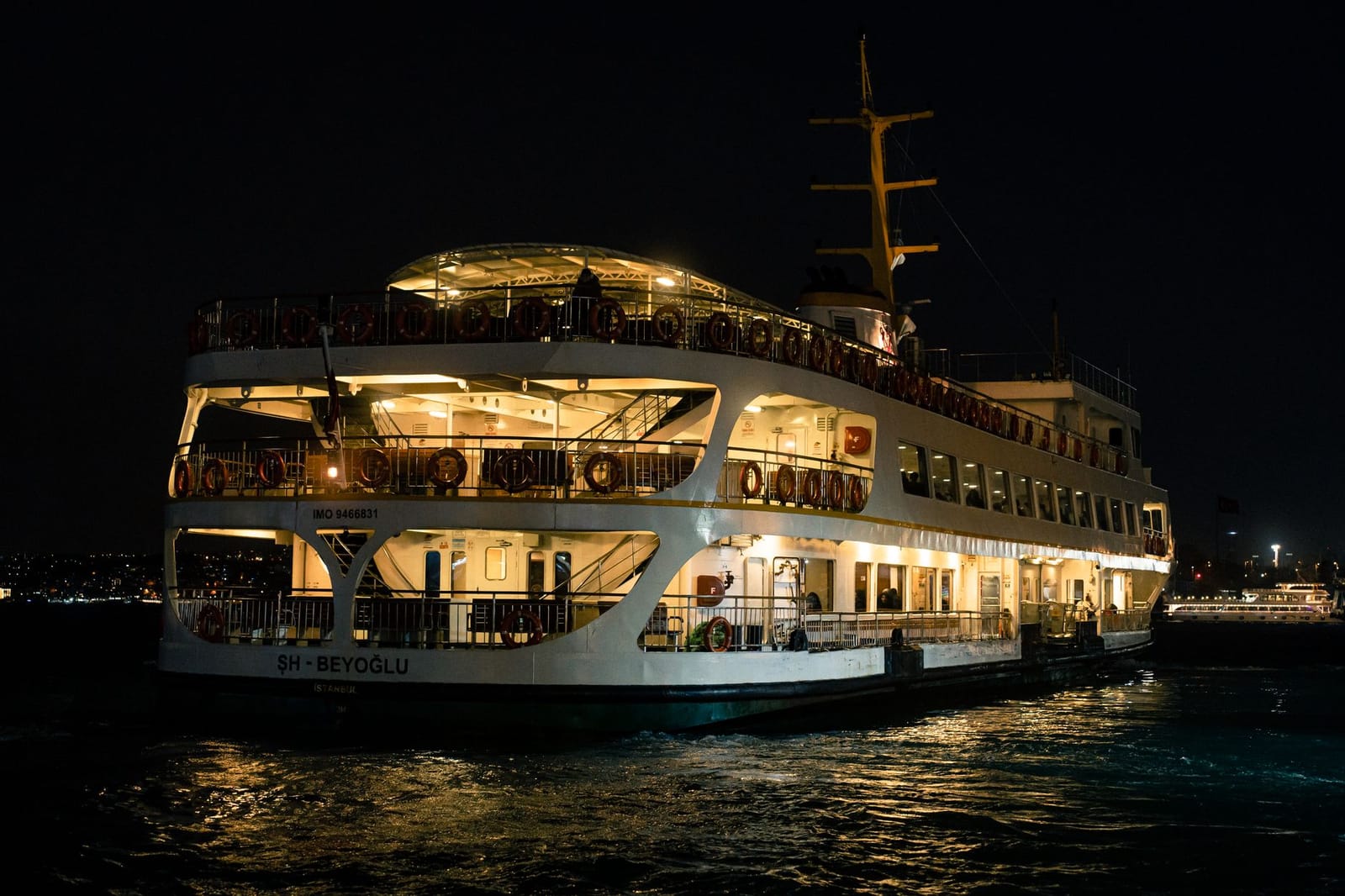 Ferry nocturno navegando por las aguas iluminadas del estrecho del Bósforo.