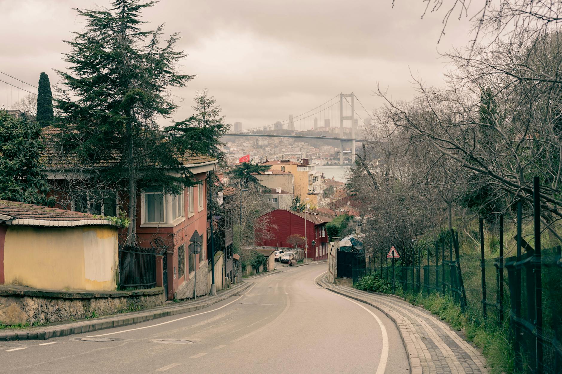 Vista desde una calle de Teşvikiye hacia el Puente del Bósforo bajo un cielo nublado.