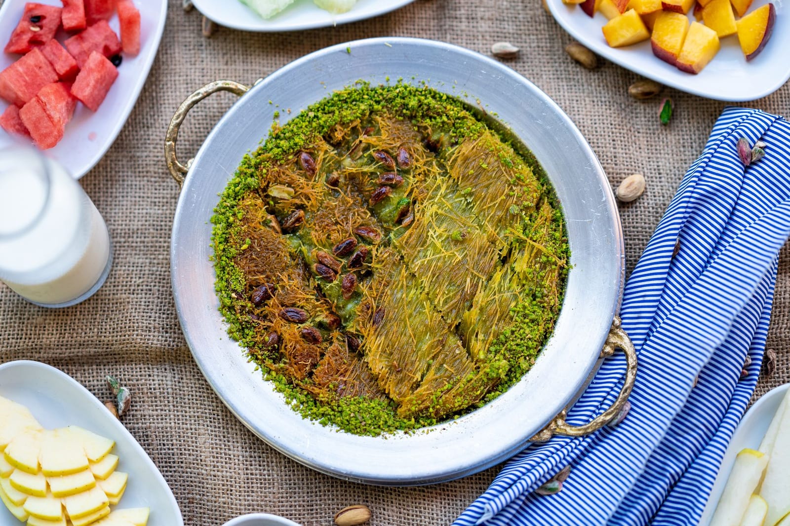 Künefe tradicional turco servido con pistachos molidos en bandeja metálica.