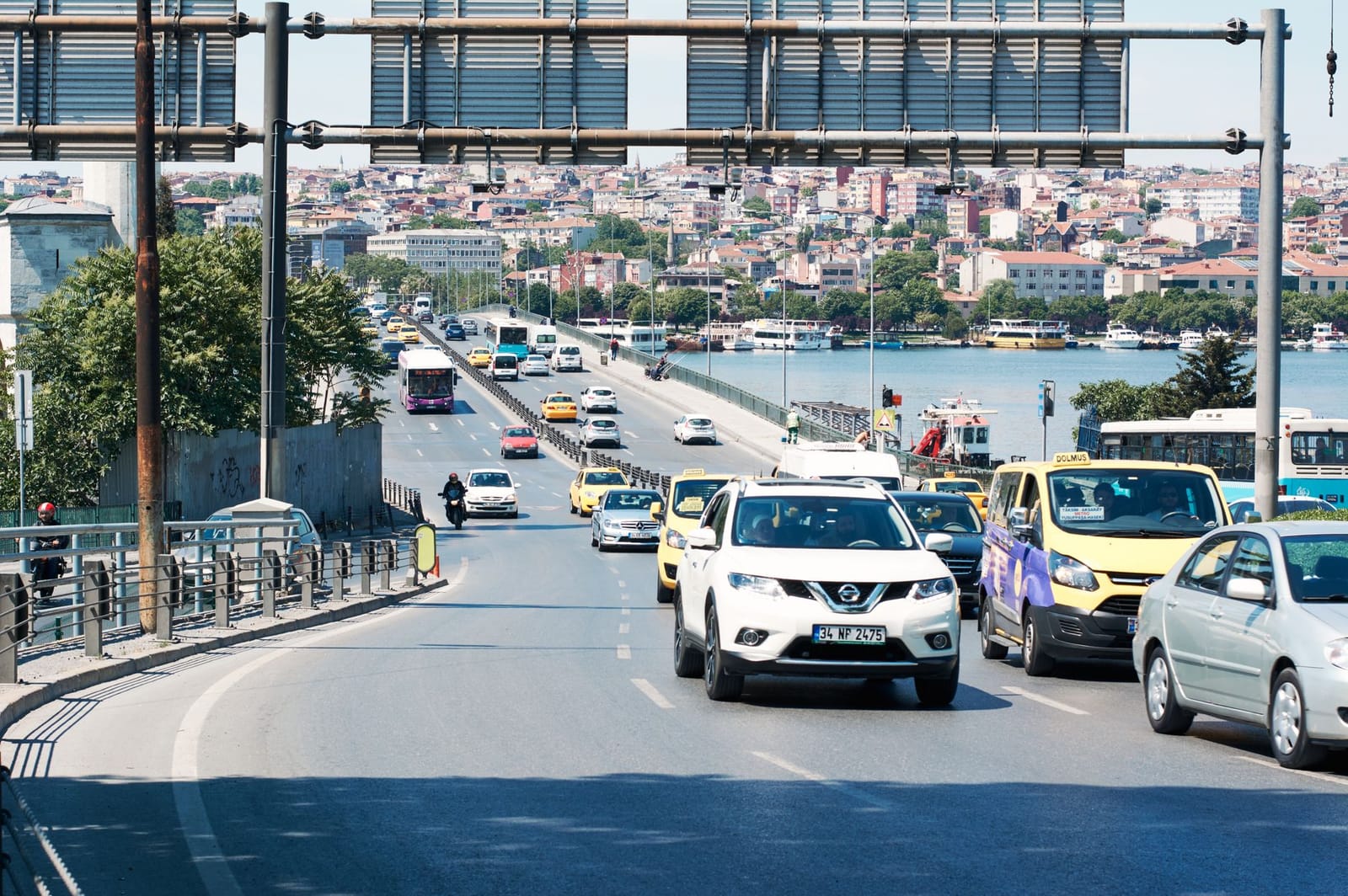 Vehículos cruzando un puente con señalización vial hacia el centro histórico de Estambul.
