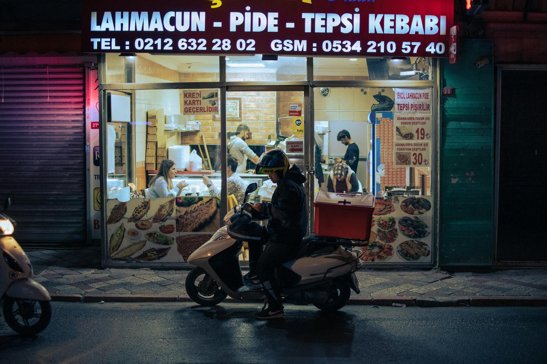 Fachada nocturna de un local tradicional de lahmacun y pide en Kadıköy.