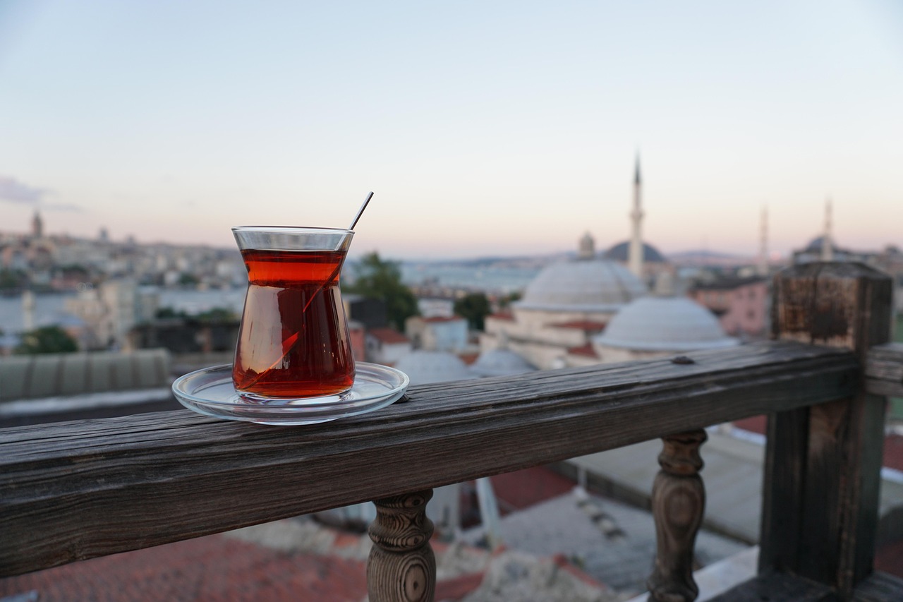 Vaso de té turco en una barandilla con vistas a los tejados de Estambul.